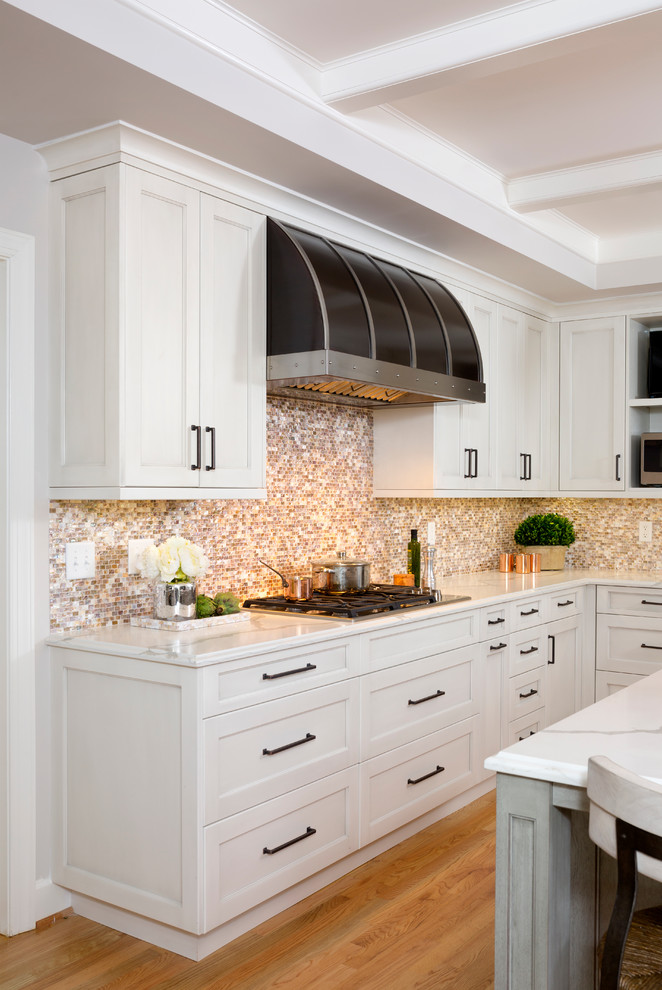 Photo of a large rustic l-shaped enclosed kitchen in DC Metro with shaker cabinets, white cabinets, engineered stone countertops, multi-coloured splashback, mosaic tiled splashback, an island, stainless steel appliances, a submerged sink, light hardwood flooring, brown floors and white worktops.