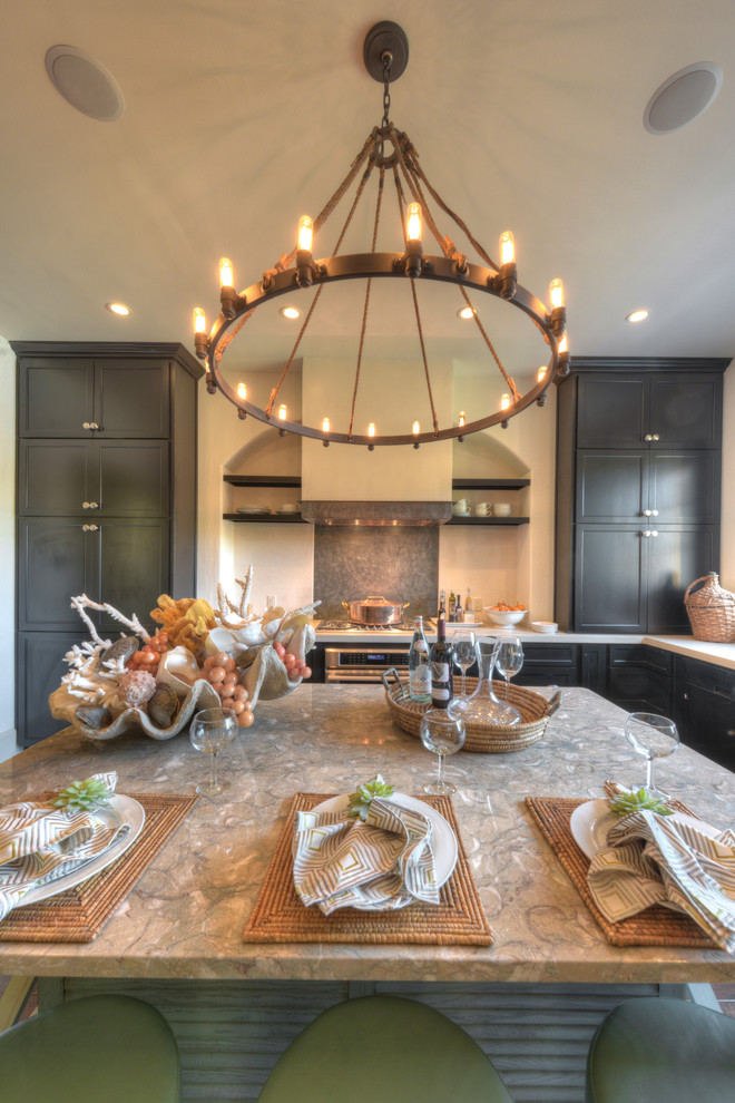 Foto di un cucina con isola centrale tradizionale con ante nere, elettrodomestici in acciaio inossidabile e parquet chiaro
