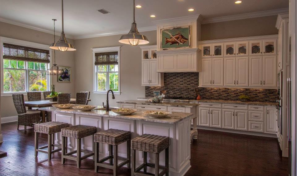 Exempel på ett stort klassiskt grå grått kök, med en undermonterad diskho, luckor med upphöjd panel, vita skåp, granitbänkskiva, brunt stänkskydd, stänkskydd i stickkakel, rostfria vitvaror, mörkt trägolv, flera köksöar och brunt golv