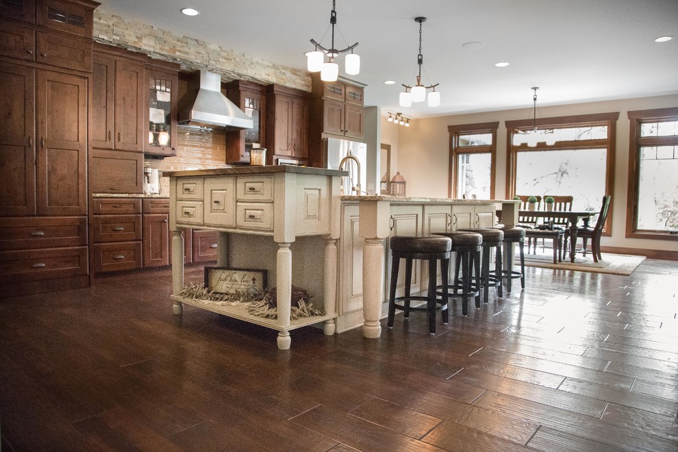 Large arts and crafts single-wall dark wood floor and brown floor eat-in kitchen photo in Other with stainless steel appliances, an island, shaker cabinets, dark wood cabinets, granite countertops, beige backsplash, ceramic backsplash and an undermount sink