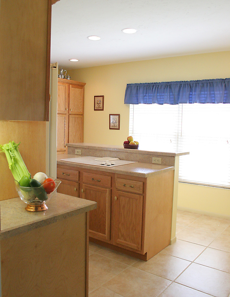 На фото: большая параллельная кухня в классическом стиле с светлыми деревянными фасадами, столешницей из ламината, белой техникой, островом, обеденным столом, полом из керамической плитки и врезной мойкой с