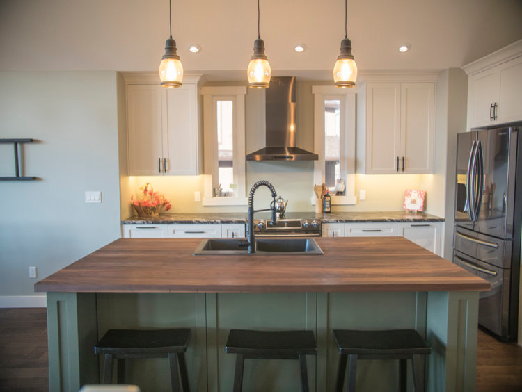Example of a mid-sized trendy l-shaped dark wood floor and brown floor eat-in kitchen design in Calgary with a drop-in sink, shaker cabinets, white cabinets, laminate countertops, stainless steel appliances and an island
