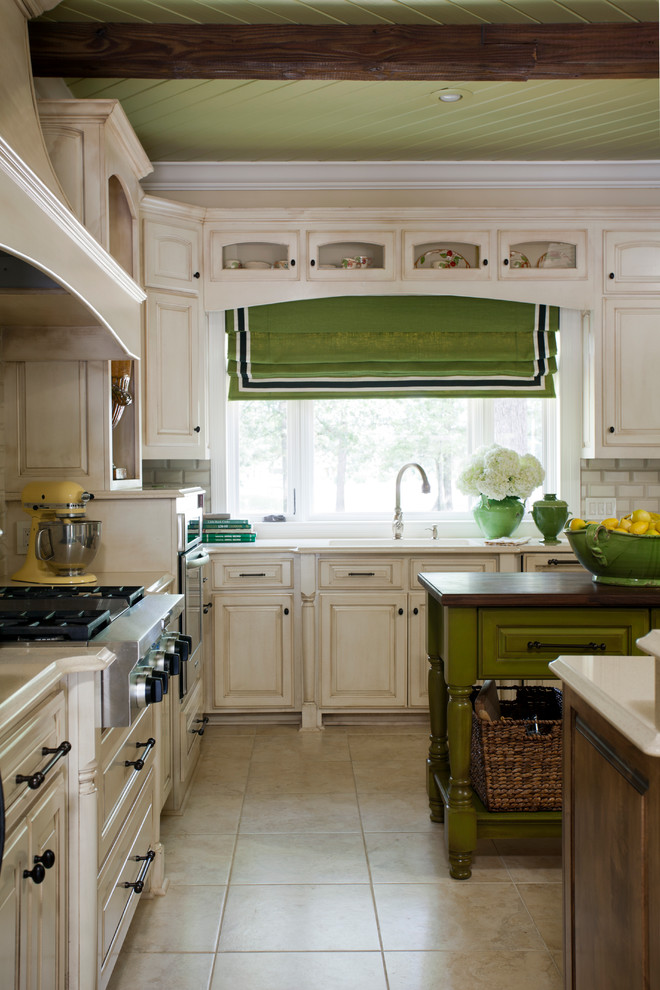 Example of a mid-sized classic ceramic tile eat-in kitchen design in Little Rock with a double-bowl sink, raised-panel cabinets, distressed cabinets, quartz countertops, beige backsplash, subway tile backsplash, stainless steel appliances and two islands