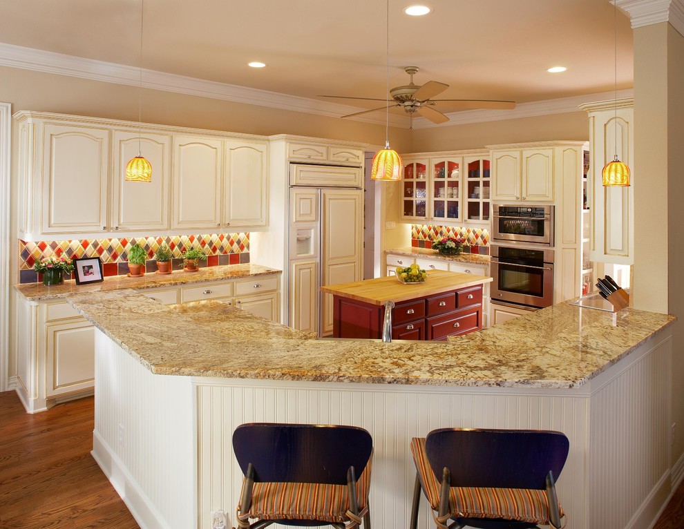 Elegant kitchen photo in Dallas with raised-panel cabinets, granite countertops, multicolored backsplash and ceramic backsplash