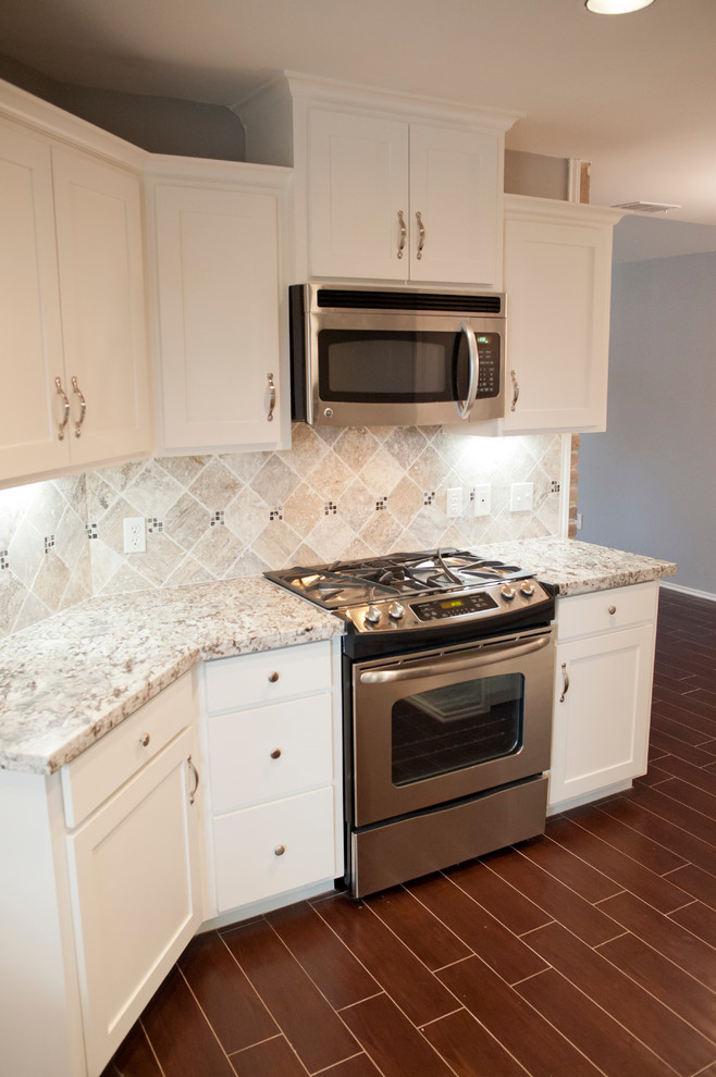Mid-sized transitional u-shaped porcelain tile enclosed kitchen photo in Houston with an undermount sink, recessed-panel cabinets, white cabinets, granite countertops, gray backsplash, stone tile backsplash and stainless steel appliances