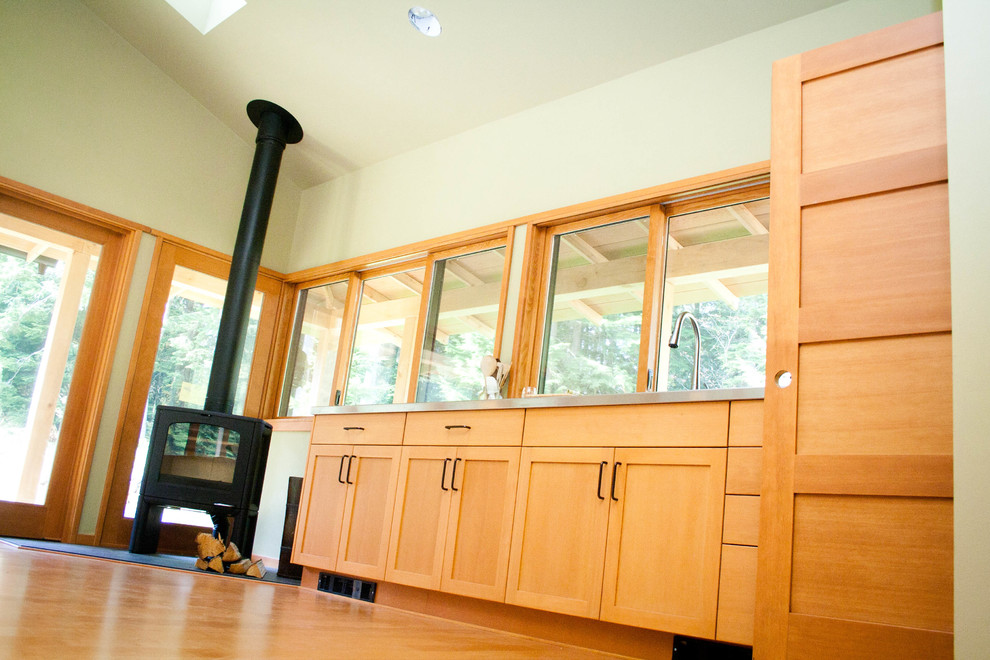 Imagen de cocina lineal de estilo zen grande abierta con armarios estilo shaker, puertas de armario de madera oscura y suelo de madera en tonos medios