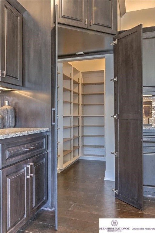 Kitchen pantry - large traditional l-shaped dark wood floor kitchen pantry idea in Omaha with a double-bowl sink, raised-panel cabinets, dark wood cabinets, granite countertops, beige backsplash, ceramic backsplash, stainless steel appliances and an island