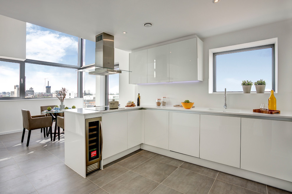 Offene Moderne Küche ohne Insel in L-Form mit flächenbündigen Schrankfronten, weißen Schränken und Küchengeräten aus Edelstahl in London
