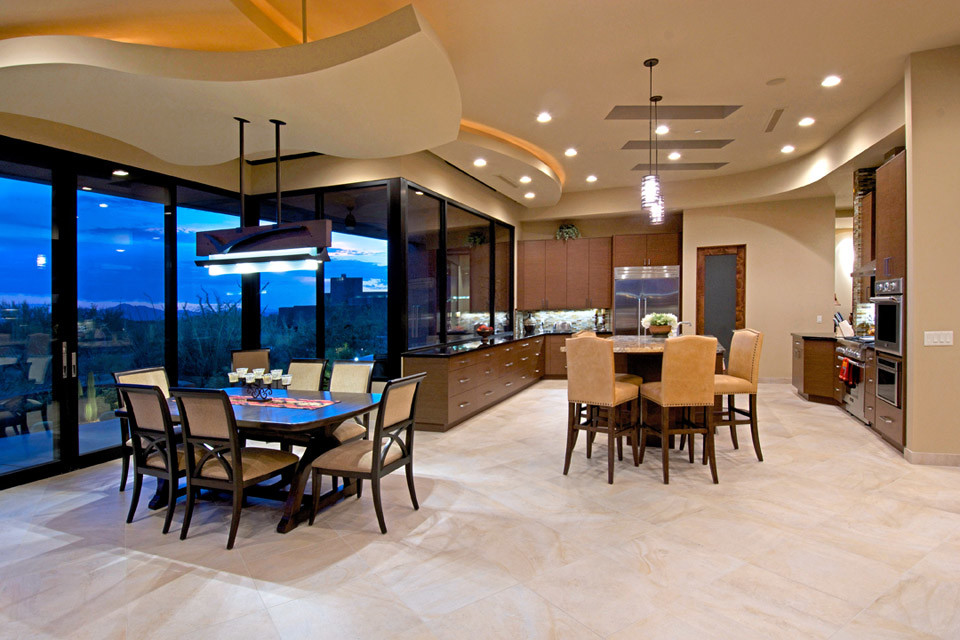 Example of a southwest u-shaped travertine floor open concept kitchen design in Phoenix with an undermount sink, flat-panel cabinets, medium tone wood cabinets, granite countertops, stone tile backsplash, white appliances and two islands