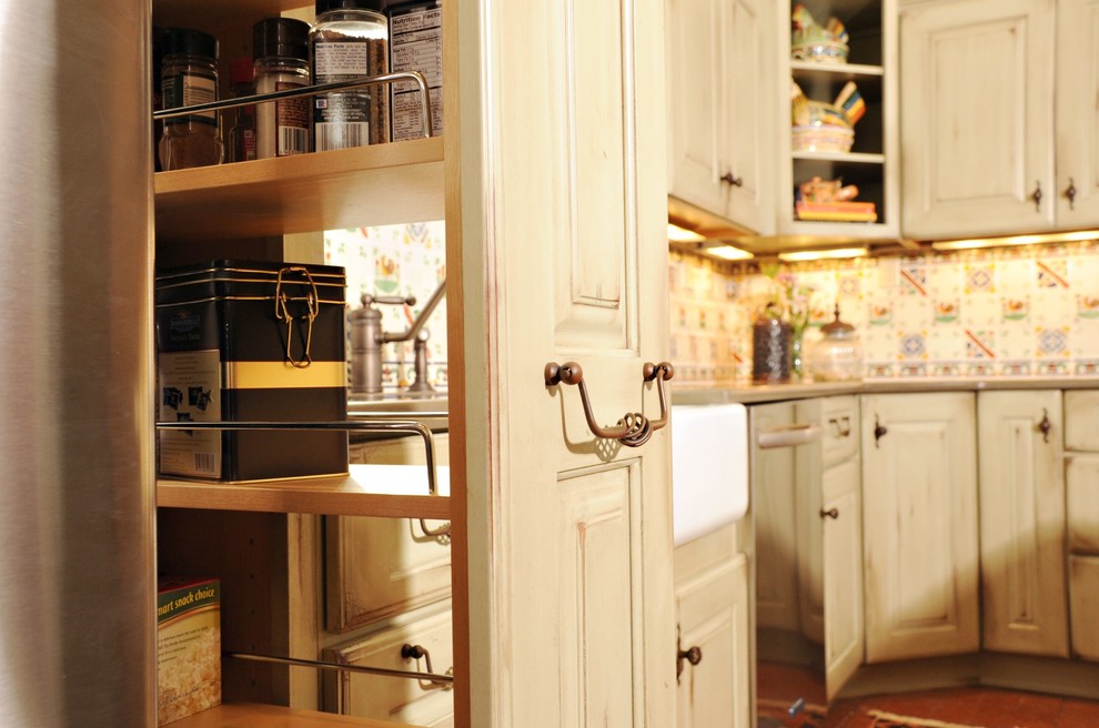 Amerikansk inredning av ett avskilt, mellanstort l-kök, med en rustik diskho, luckor med upphöjd panel, gröna skåp, bänkskiva i kvartsit, flerfärgad stänkskydd, stänkskydd i keramik, rostfria vitvaror, klinkergolv i terrakotta och en köksö