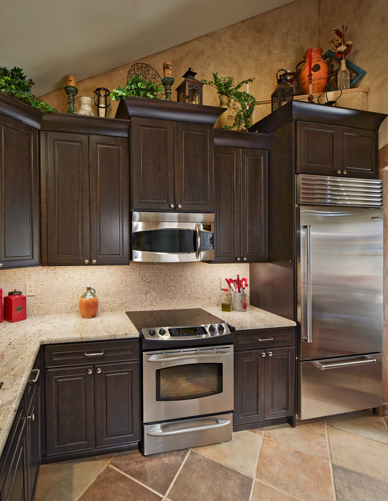 Foto på ett avskilt, litet amerikanskt linjärt kök, med en undermonterad diskho, luckor med upphöjd panel, skåp i mörkt trä, granitbänkskiva, stänkskydd i mosaik, rostfria vitvaror och klinkergolv i porslin