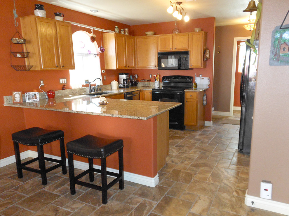 Example of a mid-sized southwest l-shaped ceramic tile eat-in kitchen design in Phoenix with a double-bowl sink, shaker cabinets, medium tone wood cabinets, granite countertops, black appliances and a peninsula