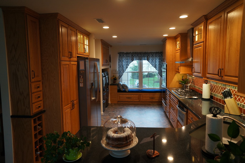 Photo of a small l-shaped kitchen/diner in Philadelphia with a submerged sink, raised-panel cabinets, medium wood cabinets, engineered stone countertops, brown splashback, terracotta splashback, stainless steel appliances, lino flooring and no island.