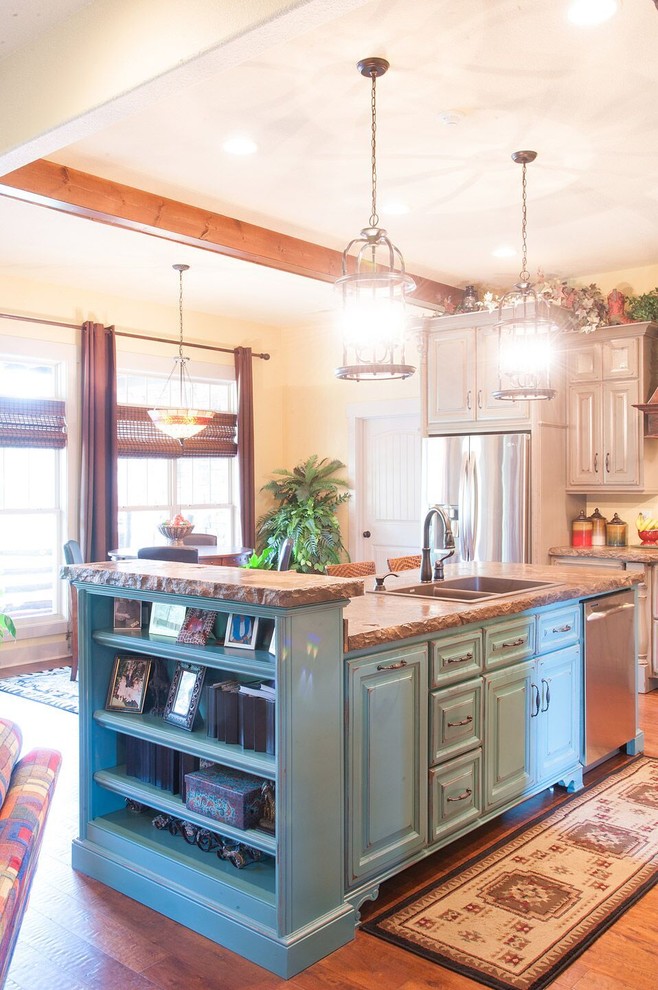 Bild på ett mellanstort amerikanskt kök, med en nedsänkt diskho, luckor med upphöjd panel, blå skåp, bänkskiva i täljsten, rostfria vitvaror, mellanmörkt trägolv och en köksö