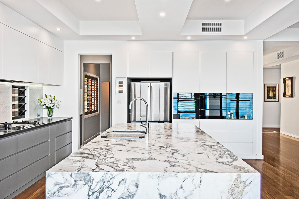 Contemporary u-shaped kitchen in Brisbane with a built-in sink, flat-panel cabinets, white cabinets, stainless steel appliances and an island.