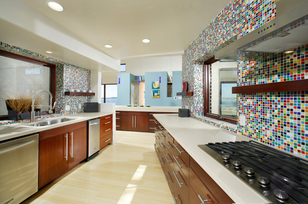 На фото: кухня в современном стиле с плоскими фасадами, фартуком из плитки мозаики, техникой из нержавеющей стали, двойной мойкой, темными деревянными фасадами, разноцветным фартуком и красивой плиткой с