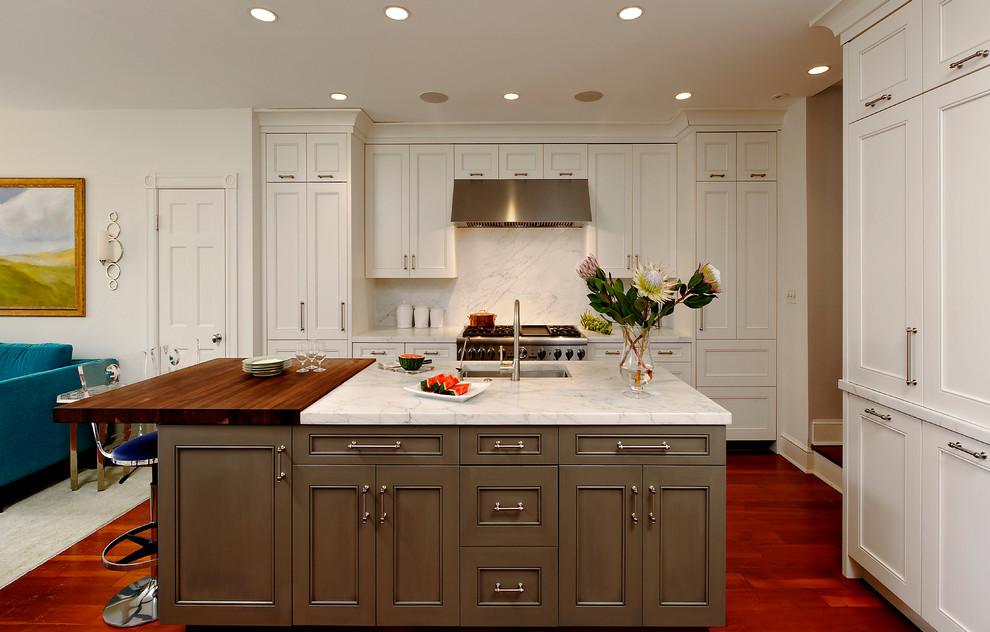 Idéer för ett klassiskt kök med öppen planlösning, med en undermonterad diskho, luckor med infälld panel, vita skåp, marmorbänkskiva, rostfria vitvaror, mellanmörkt trägolv och en köksö