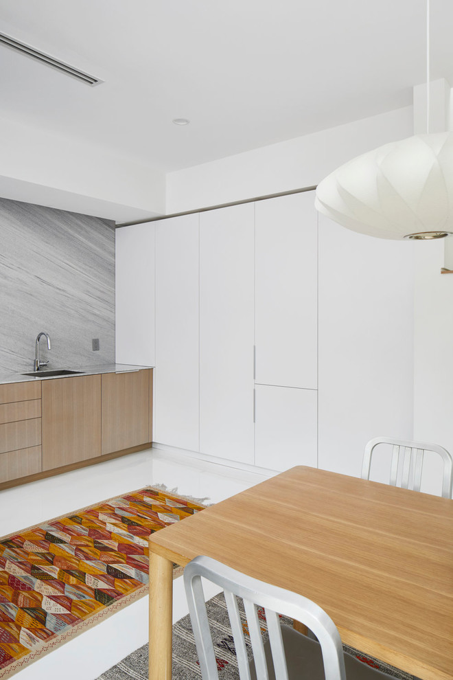 Modern inredning av ett grå linjärt grått kök och matrum, med marmorbänkskiva, grått stänkskydd och stänkskydd i marmor