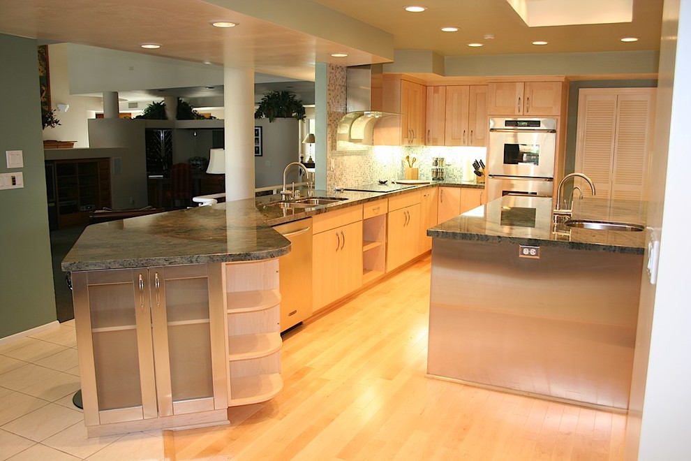 Huge trendy u-shaped light wood floor open concept kitchen photo in Other with an undermount sink, flat-panel cabinets, light wood cabinets, granite countertops, green backsplash, glass tile backsplash, stainless steel appliances and an island