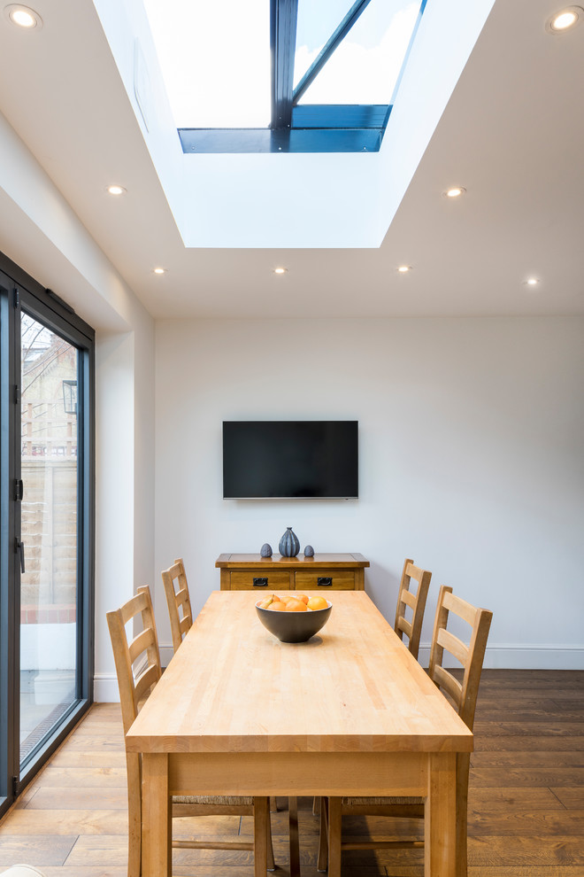 Photo of a large contemporary kitchen/dining room in London with medium hardwood flooring and brown floors.