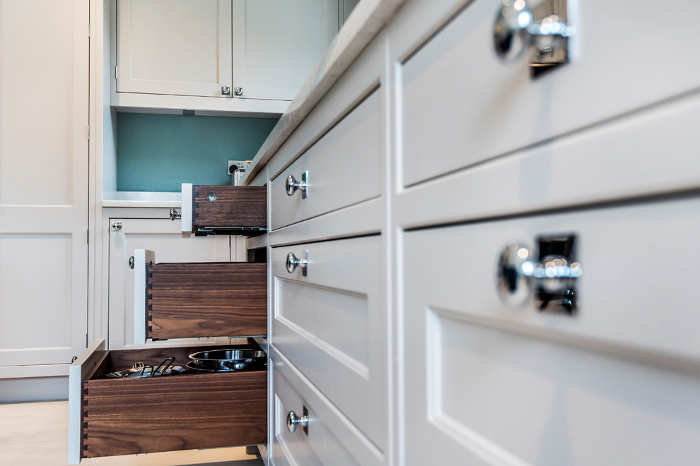 Ejemplo de cocinas en L tradicional abierta con armarios estilo shaker, puertas de armario grises, salpicadero beige, una isla, suelo gris y encimeras grises