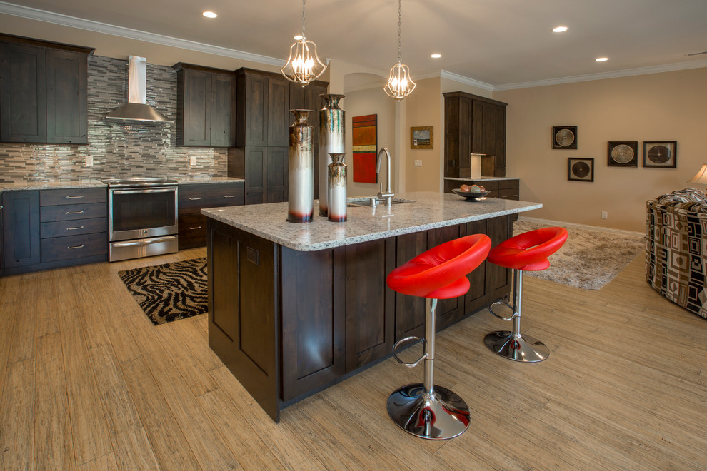 Example of a trendy bamboo floor kitchen design in Cincinnati with a drop-in sink, glass tile backsplash, stainless steel appliances and an island