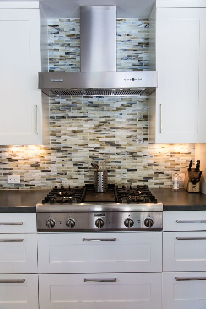 Example of a large trendy l-shaped medium tone wood floor open concept kitchen design in Denver with shaker cabinets, white cabinets, no island, concrete countertops, multicolored backsplash, matchstick tile backsplash, stainless steel appliances and a farmhouse sink