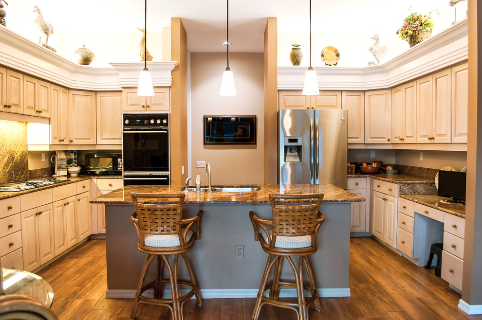 Exemple d'une grande cuisine exotique avec un plan de travail en granite et un sol en bois brun.