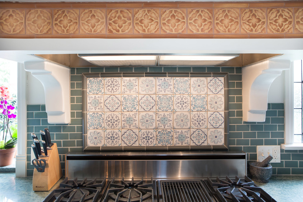 Foto di una cucina mediterranea di medie dimensioni con lavello da incasso, ante in stile shaker, ante bianche, top in granito, paraspruzzi blu, paraspruzzi con piastrelle in ceramica e elettrodomestici in acciaio inossidabile