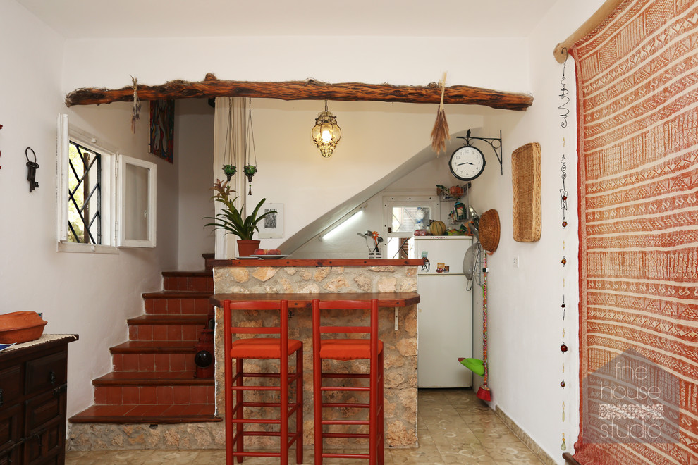 グロスタシャーにあるお手頃価格の小さな地中海スタイルのおしゃれな独立型キッチン (木材カウンター、磁器タイルの床) の写真