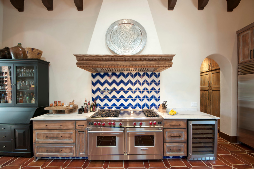 This is an example of a mediterranean kitchen in Austin with distressed cabinets.
