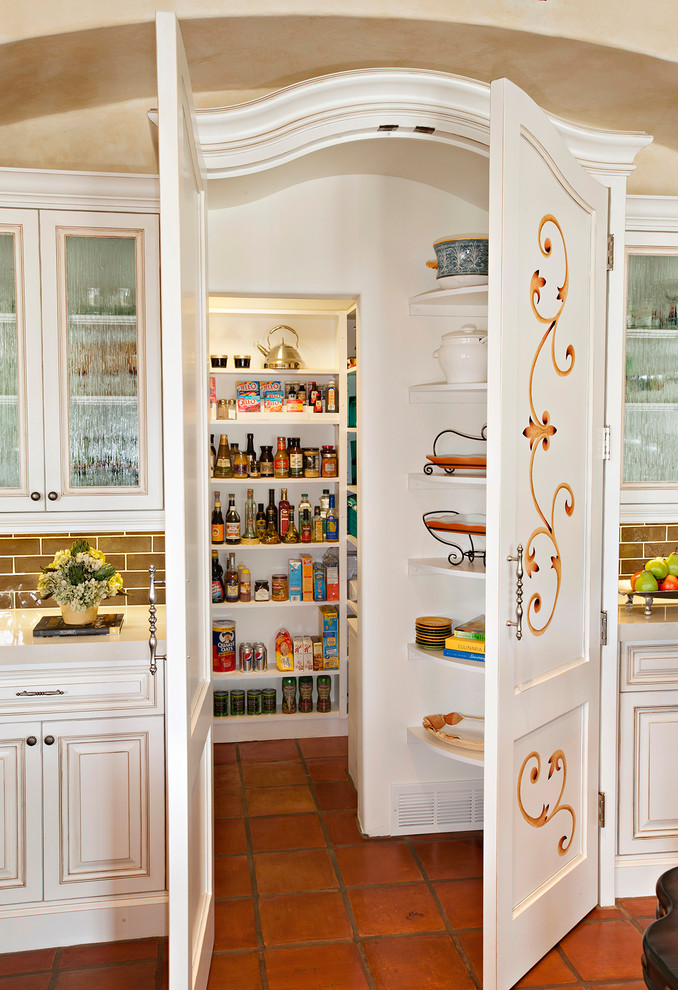Imagen de cocina mediterránea con armarios con paneles con relieve, puertas de armario blancas, salpicadero marrón, salpicadero de azulejos tipo metro y despensa