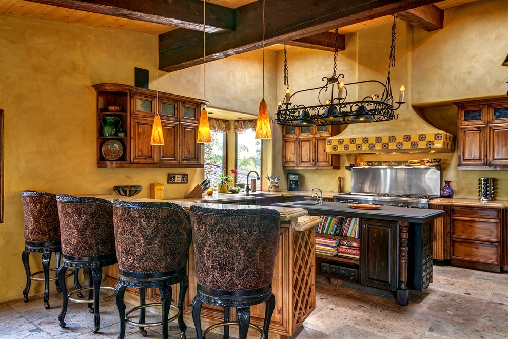 サンディエゴにある巨大なサンタフェスタイルのおしゃれなキッチン (濃色木目調キャビネット、御影石カウンター、シルバーの調理設備) の写真