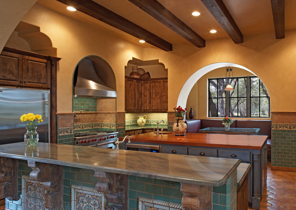 This is an example of a mediterranean kitchen in Austin with stainless steel appliances.