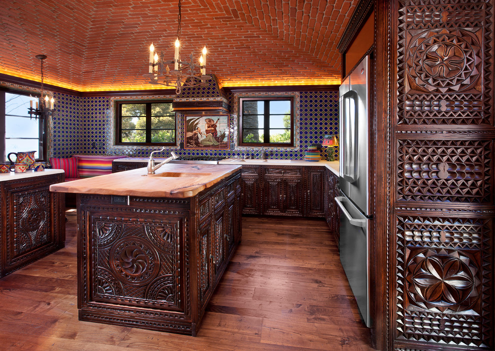 サンタバーバラにある広い地中海スタイルのおしゃれなキッチン (濃色木目調キャビネット、マルチカラーのキッチンパネル、シルバーの調理設備、無垢フローリング) の写真