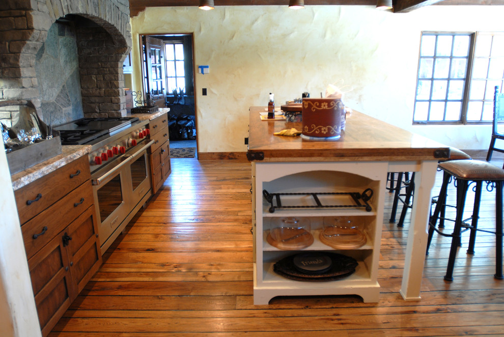 Exemple d'une cuisine méditerranéenne en bois brun de taille moyenne avec un électroménager en acier inoxydable et un sol en bois brun.