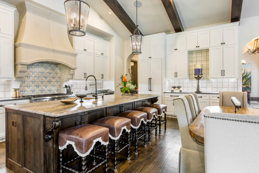 Inspiration for a mediterranean u-shaped open plan kitchen in Dallas with shaker cabinets, multi-coloured splashback, stainless steel appliances, dark hardwood flooring, an island, brown floors and a vaulted ceiling.