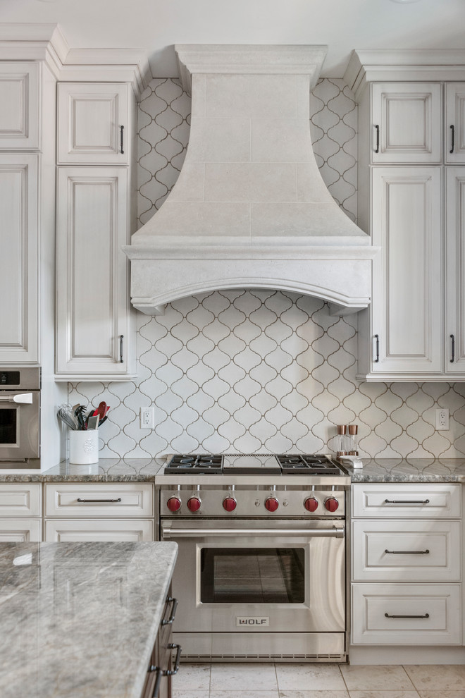 Example of a large tuscan u-shaped ceramic tile and beige floor open concept kitchen design in Tampa with a farmhouse sink, recessed-panel cabinets, beige cabinets, granite countertops, white backsplash, ceramic backsplash, stainless steel appliances, an island and gray countertops