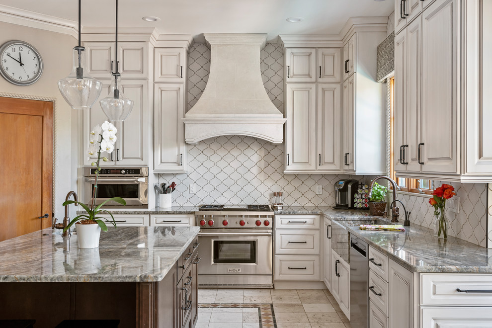 Idéer för ett stort medelhavsstil grå l-kök, med en rustik diskho, granitbänkskiva, vitt stänkskydd, stänkskydd i keramik, rostfria vitvaror, klinkergolv i keramik, en köksö, luckor med upphöjd panel, flerfärgat golv och vita skåp