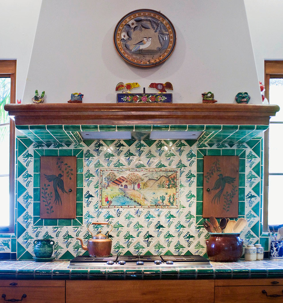 На фото: кухня в стиле фьюжн с столешницей из плитки и зеленым фартуком