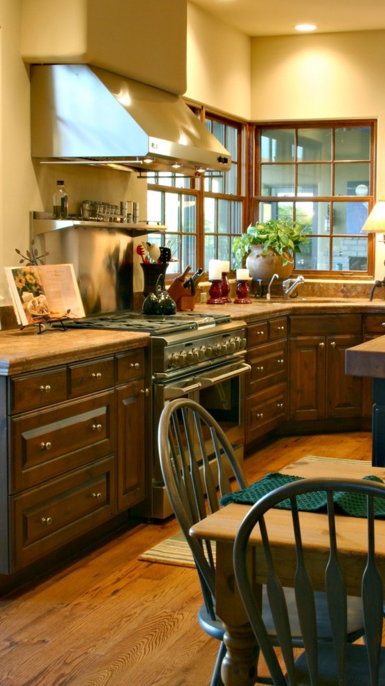 Example of a southwest medium tone wood floor kitchen design in Phoenix with an undermount sink, beaded inset cabinets, dark wood cabinets, wood countertops, brown backsplash, ceramic backsplash, stainless steel appliances and an island