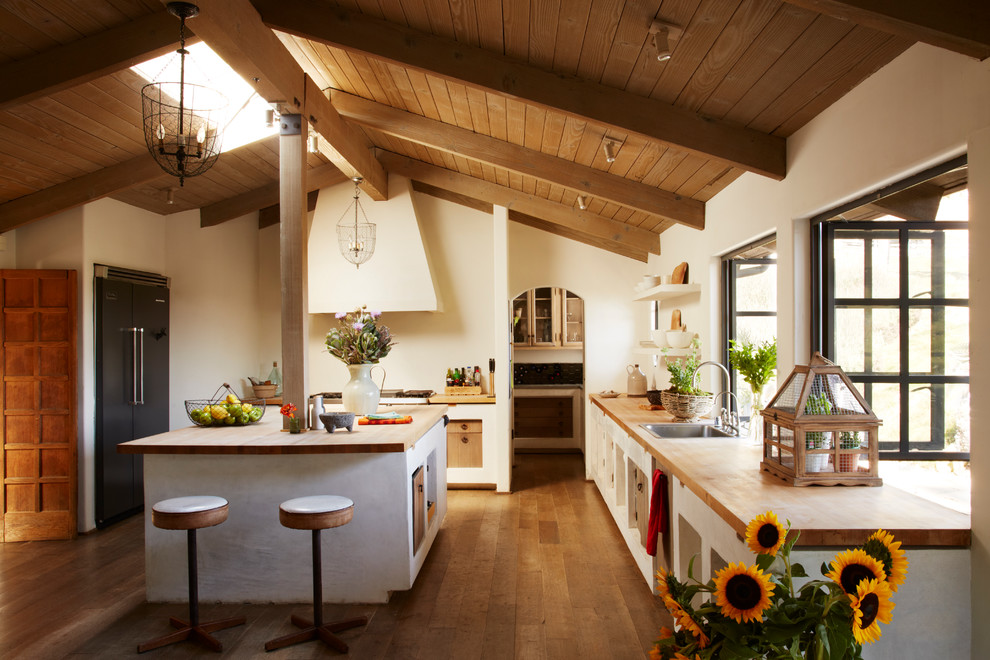 Mediterrane Küche in L-Form mit braunem Holzboden und Kücheninsel in Los Angeles