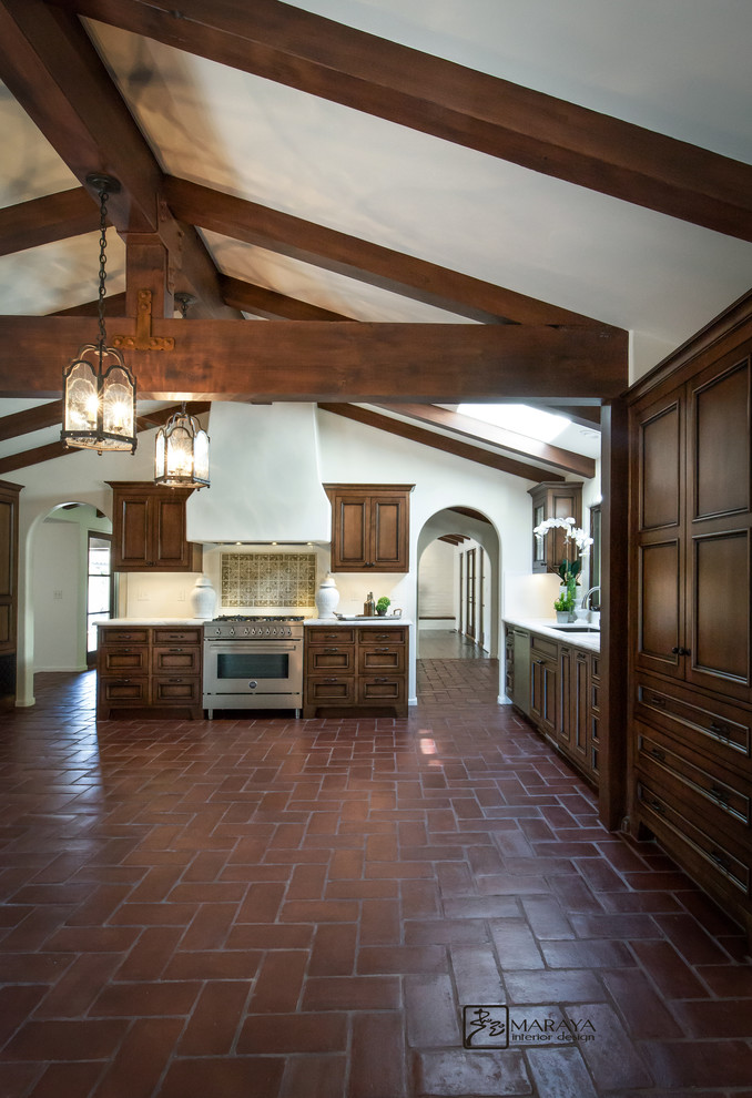 Large mediterranean u-shaped kitchen/diner in Santa Barbara with a submerged sink, recessed-panel cabinets, distressed cabinets, marble worktops, white splashback, metro tiled splashback, stainless steel appliances, terracotta flooring and no island.