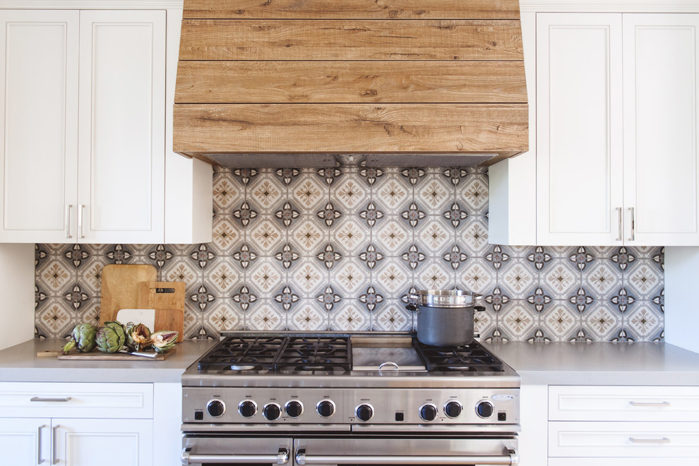 Inspiration for a mid-sized transitional l-shaped light wood floor and beige floor open concept kitchen remodel in San Diego with an undermount sink, recessed-panel cabinets, white cabinets, quartzite countertops, multicolored backsplash, cement tile backsplash, stainless steel appliances and an island