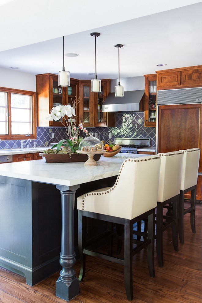 Ejemplo de cocina clásica renovada con armarios tipo vitrina, puertas de armario de madera en tonos medios, salpicadero azul y electrodomésticos con paneles