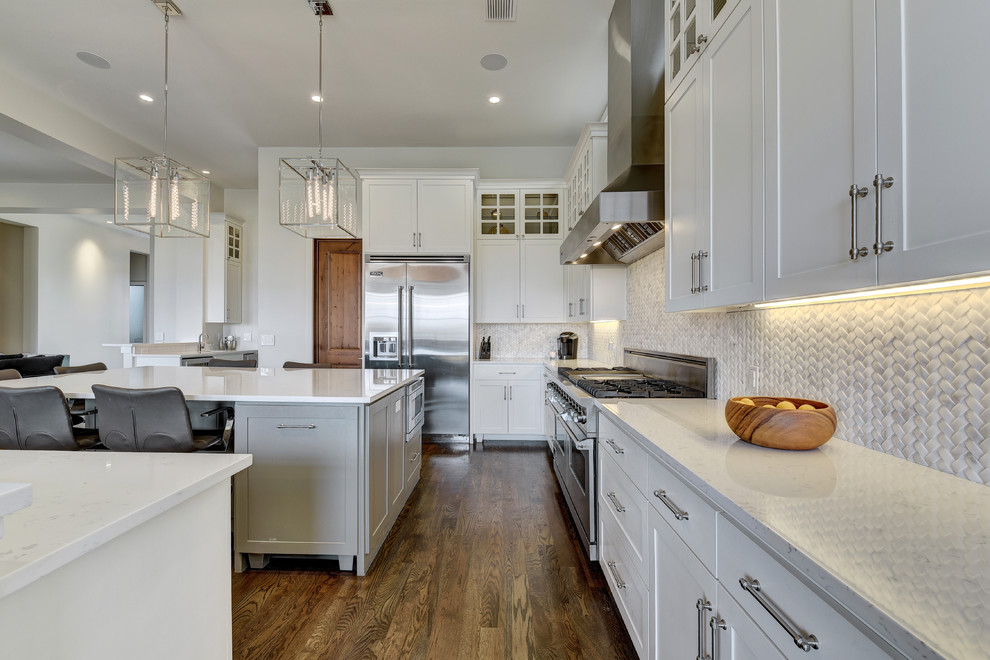 Example of a large transitional u-shaped dark wood floor eat-in kitchen design in Austin with shaker cabinets, white cabinets, white backsplash, stainless steel appliances, mosaic tile backsplash, an island, quartz countertops and a farmhouse sink