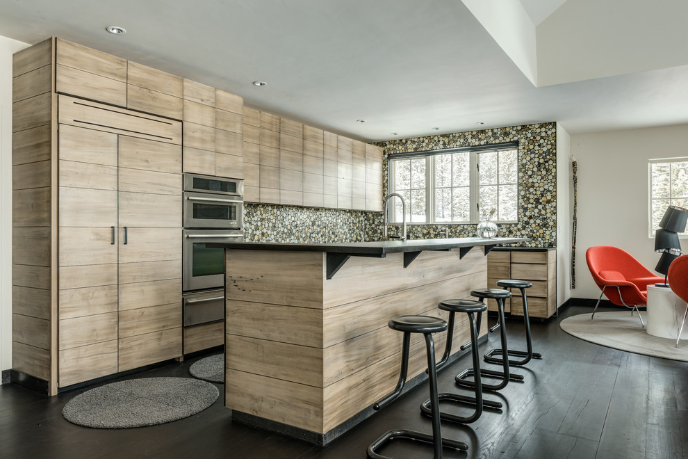 Cette image montre une grande cuisine ouverte encastrable design en bois clair avec un placard à porte plane, une crédence multicolore, parquet foncé, îlot et une crédence en carreau de verre.