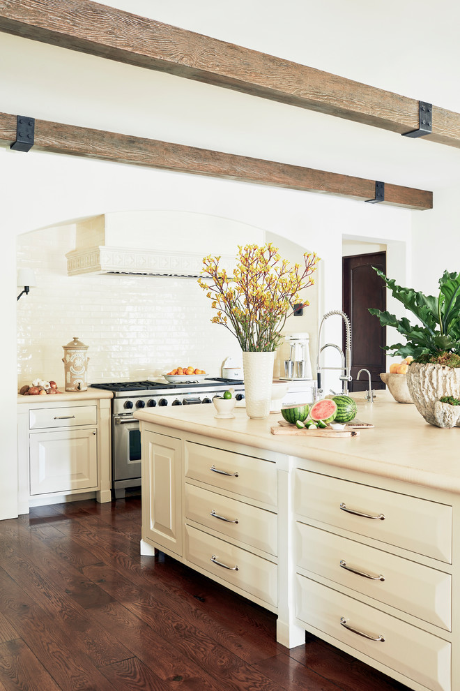 Exempel på ett mycket stort medelhavsstil beige beige kök, med en rustik diskho, luckor med upphöjd panel, vita skåp, bänkskiva i kalksten, vitt stänkskydd, stänkskydd i keramik, integrerade vitvaror, mörkt trägolv, en köksö och brunt golv