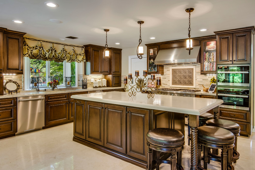 Example of a large tuscan u-shaped porcelain tile open concept kitchen design in Los Angeles with an integrated sink, beaded inset cabinets, dark wood cabinets, limestone countertops, multicolored backsplash, subway tile backsplash, stainless steel appliances and an island