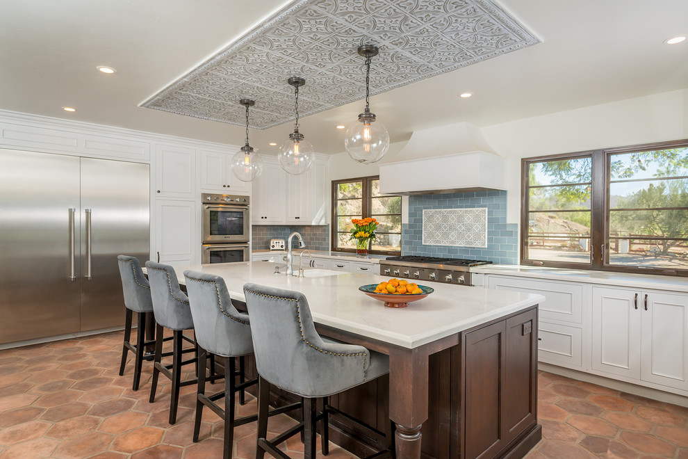 Enclosed kitchen - huge mediterranean ceramic tile enclosed kitchen idea in Los Angeles with a farmhouse sink, beaded inset cabinets, white cabinets, quartzite countertops, blue backsplash, cement tile backsplash, stainless steel appliances and an island